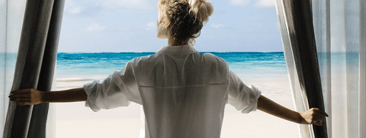 ALL-Accor Live Limitless - Woman looking out on beach from window