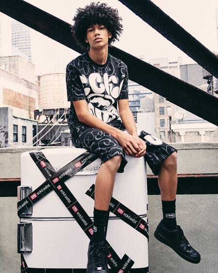 man sitting with ecko unltd tee and shorts