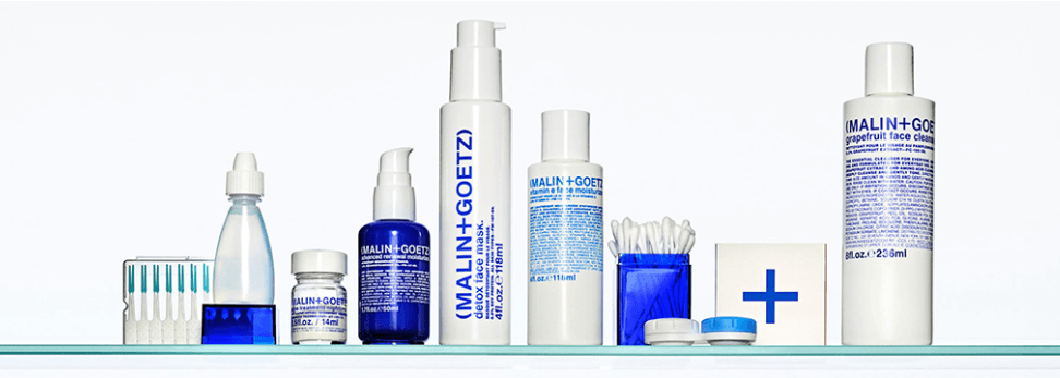 image of various Malin + Goetz products on a glass shelf