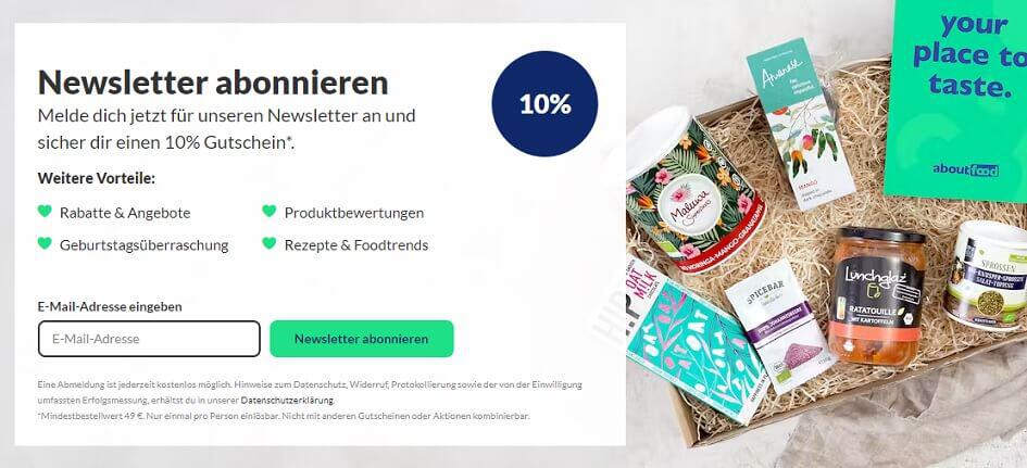 Aufruf, dich für den aboutfood Newsletter anzumelden und dabei einen 10 % aboutfood Gutschein zu erhalten, mit einem Präsentkorb als Deko an der Seite.