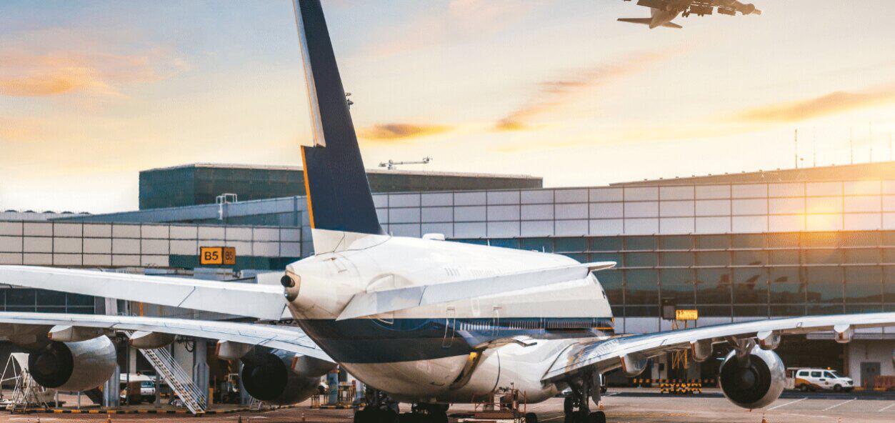 Airport Park With Us ways to save banner. Image shows an aeroplane parked outside of an airport terminal