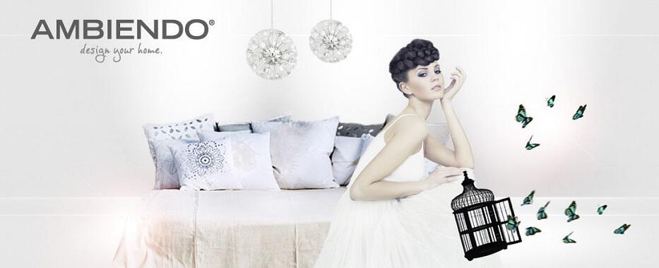 Frau auf Bett mit vielen Dekokissen und Slogan "AMBIENDO – design your home"