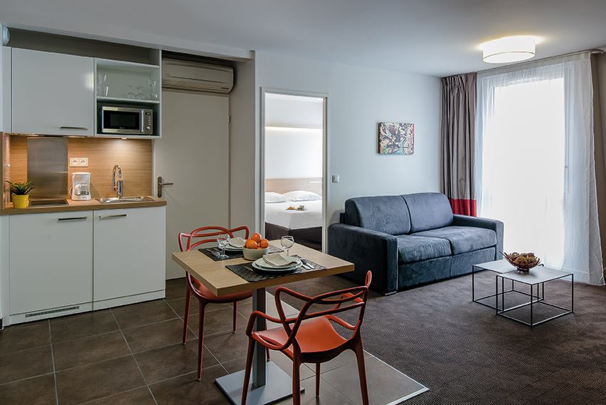 Appartement Appart&apos;City avec table dressée et canapé