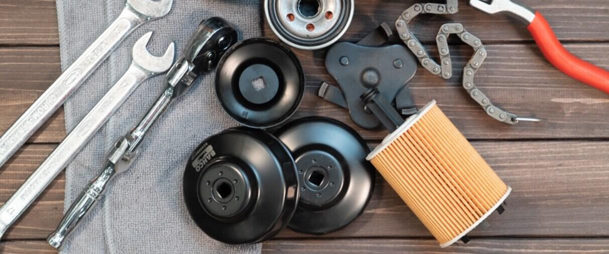 Autodoc savings page banner showing an assortment of car parts on a table