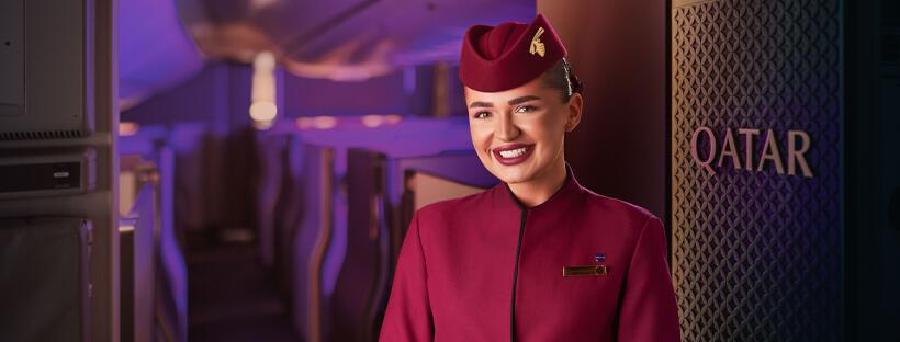 bannière photo Qatar Airways montrant une hôtesse de l&apos;air de face dans un avion
