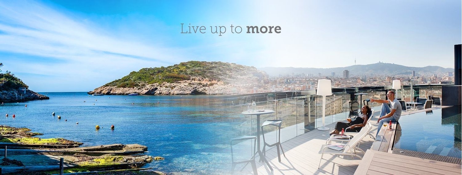 Barcelo Resort by the beach and a couple looking out to sea. Text reads: Live Up To More.