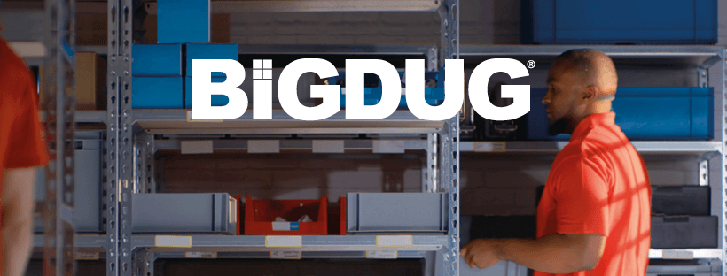 Man carrying a box while walking between industrial shelving by BiGDUG