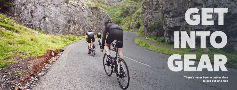 Cyclists on bikes cycling up a mountainous road with bike gear from Evans Cycles
