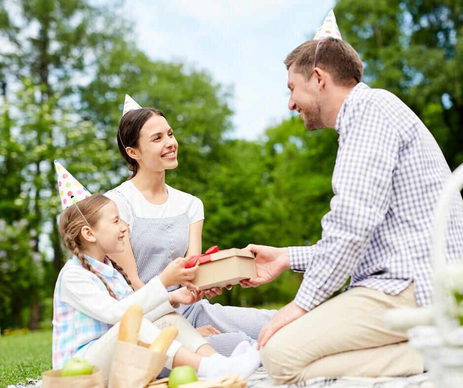 birthday picnic scene with mum, dad and daughter