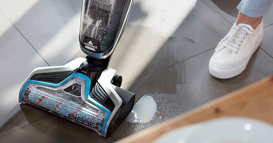 BISSELL how to save money banner featuring a close up of a branded floor cleaning appliance on a dirty floor