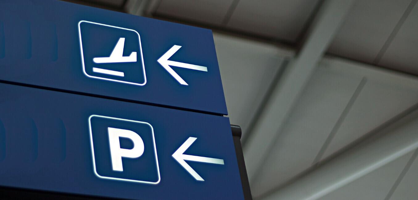 Book FHR savings guide banner - Image shows an airport sign pointing to parking