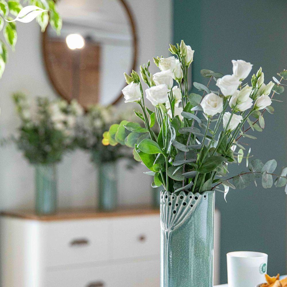 Vase vert avec bouquet de roses blanches
