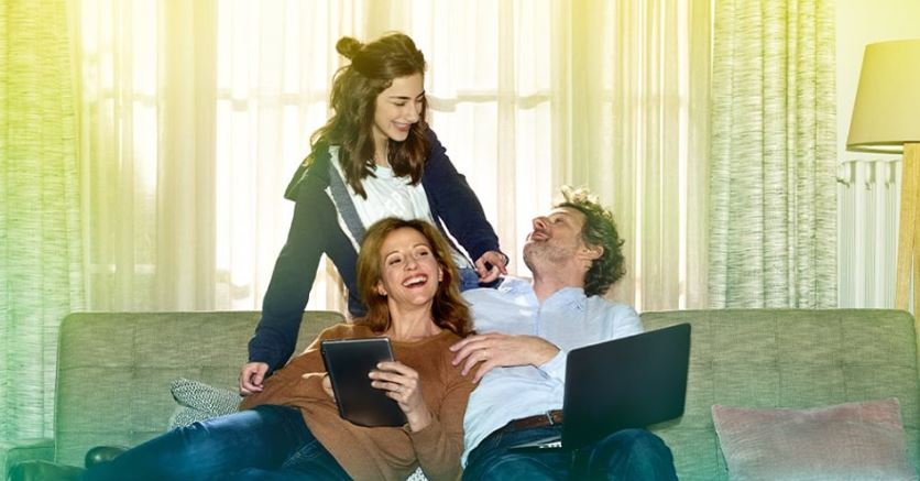 Famille sur un canapé avec des ordinateurs