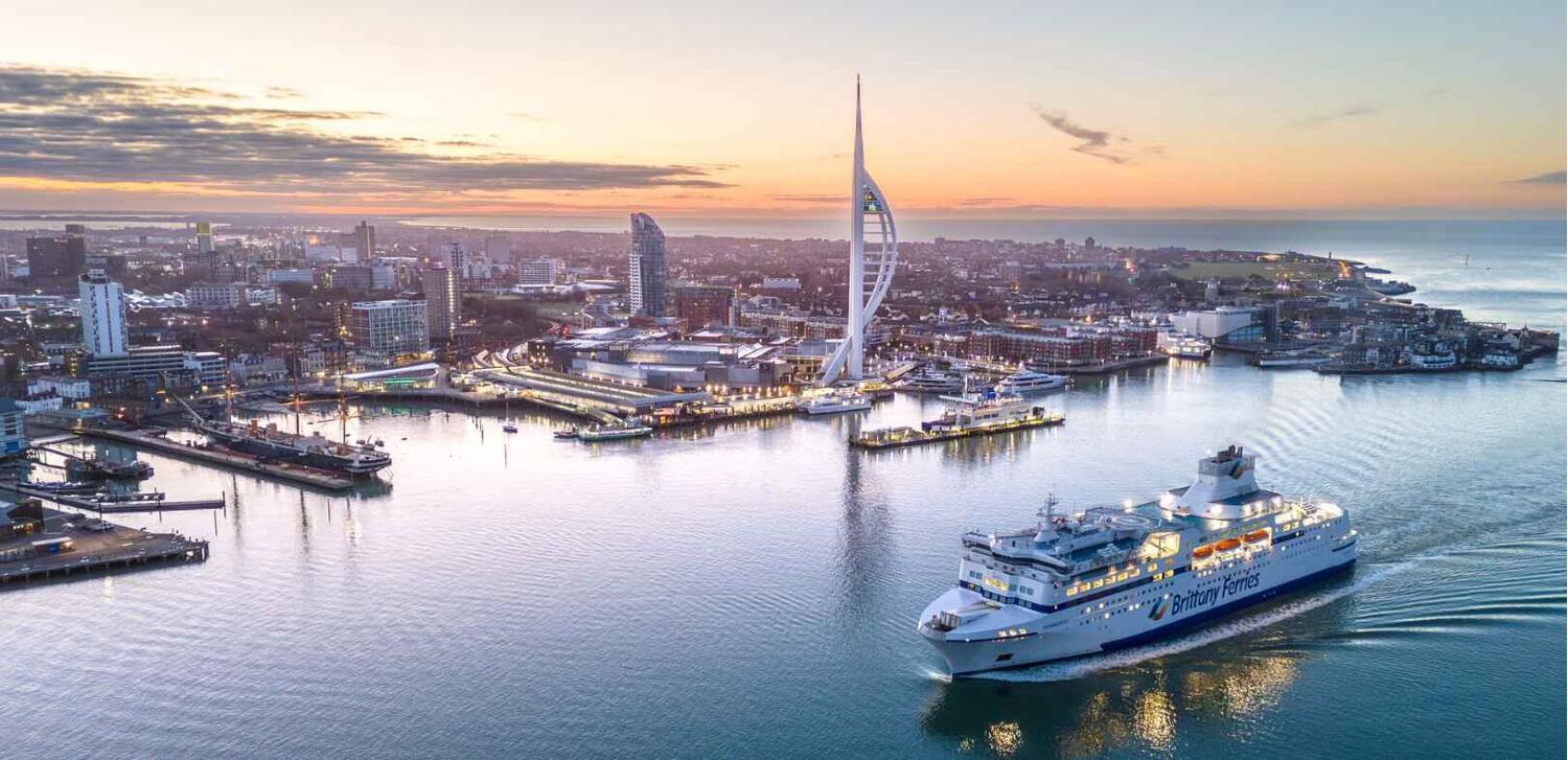 Brittany Ferries deals page image - A branded ferry in the water next to Portsmouth harbour