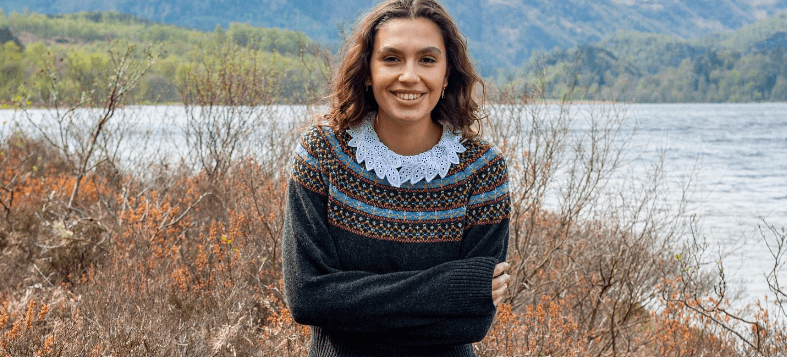 Brora savings guide image showing a woman wearing a knitwear jumper in front of a loch