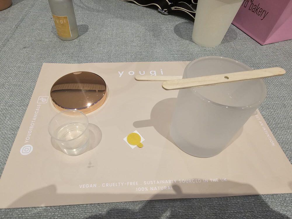 Candle-making equipment, jar, wick, and measuring pot, set up at the Yougi candle workshop