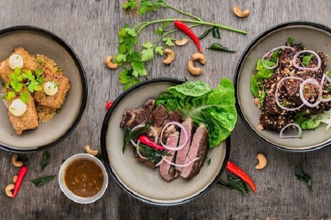 Bunte Mahlzeit mit Steak, Salat, Nüssen und Zwiebel