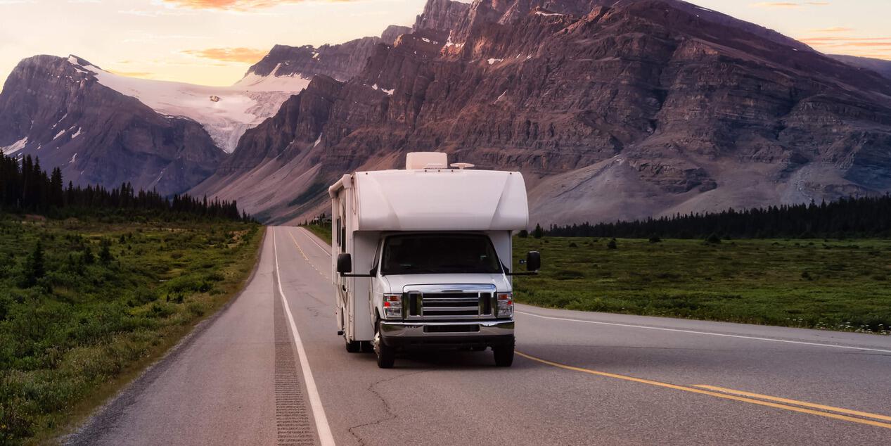 rv driving away from a mountain