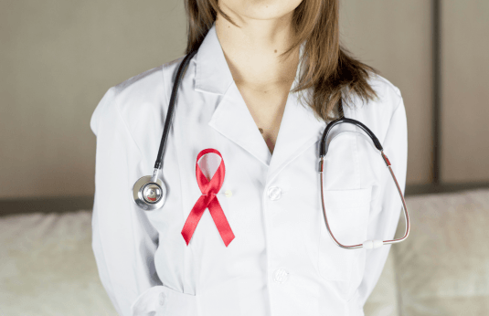 female scientist wearing a breast cancer awareness pink ribbon