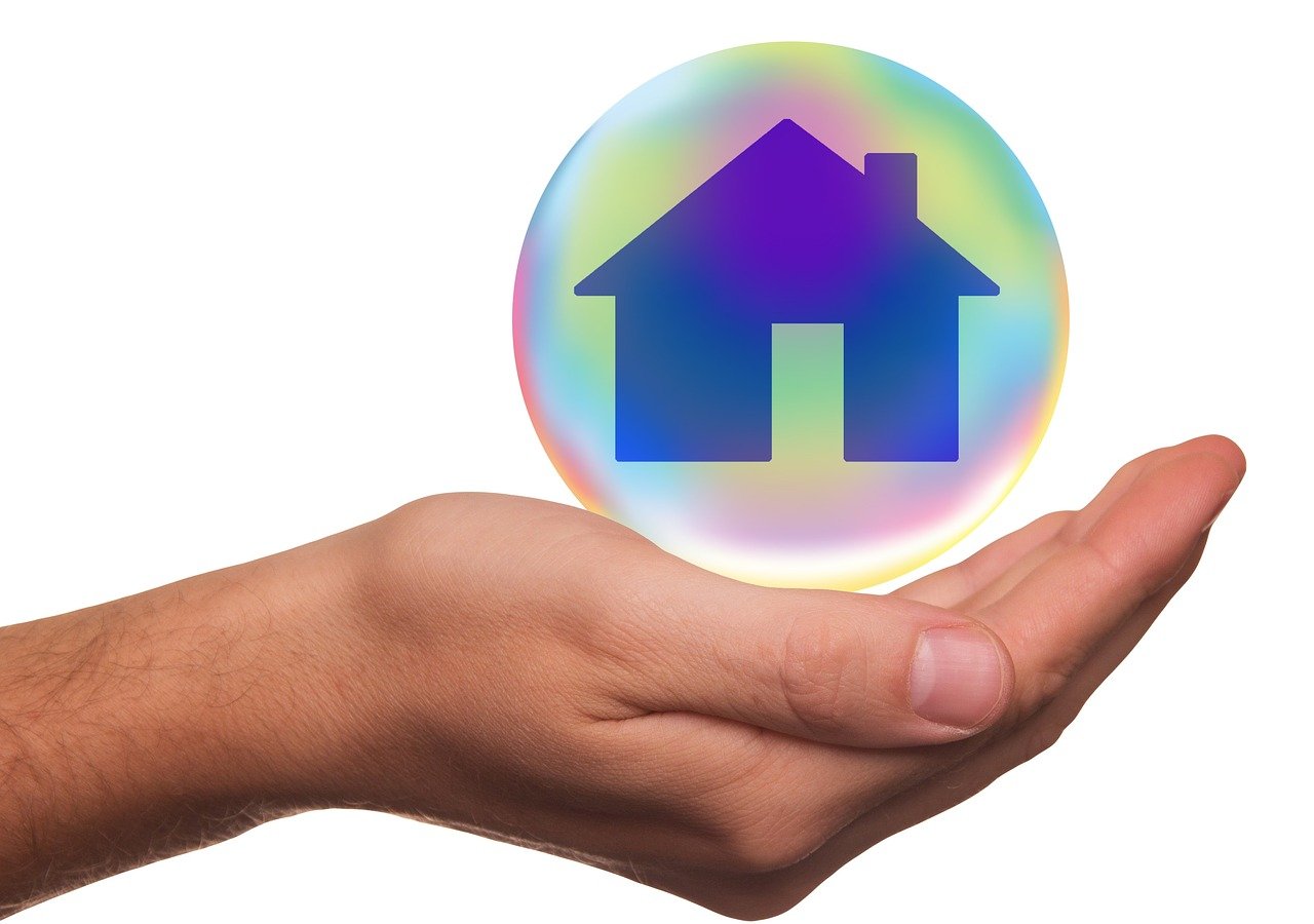 Main tenant une bulle avec une maison à l&apos;intérieur