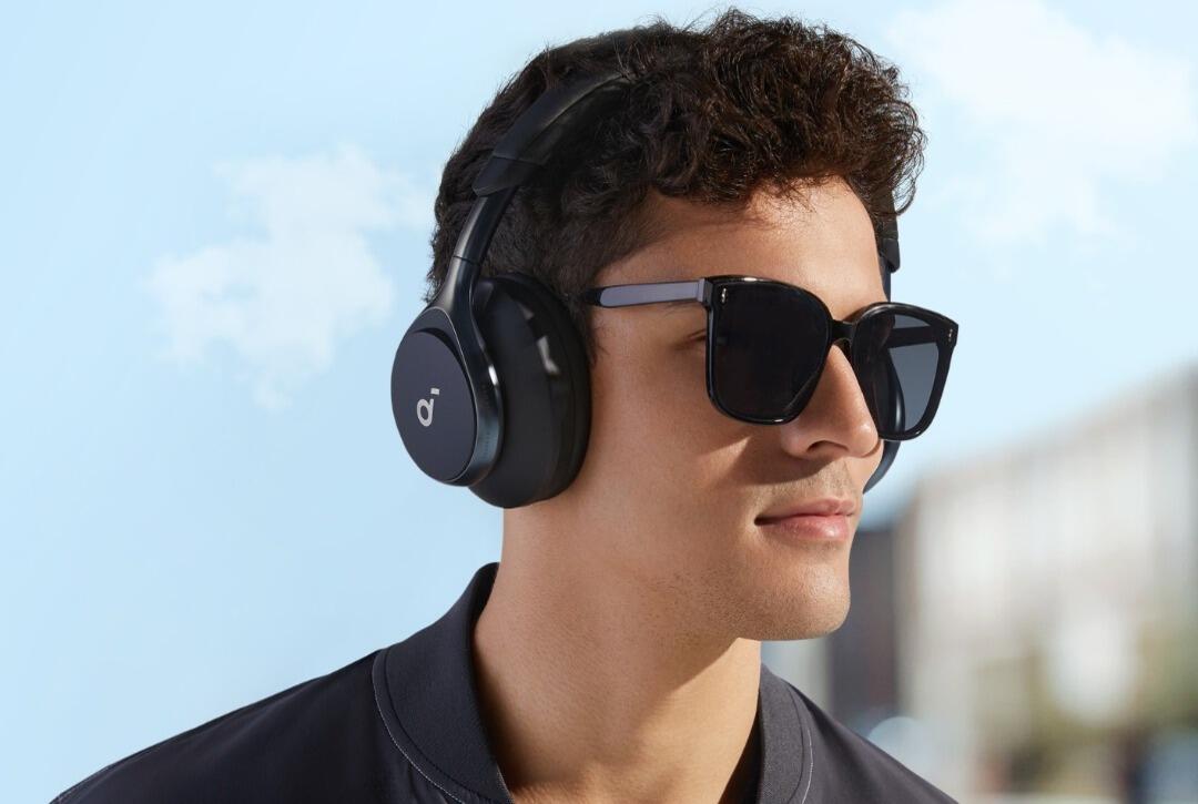 Homme portant des lunettes de soleil noires et un casque audio Soundcore