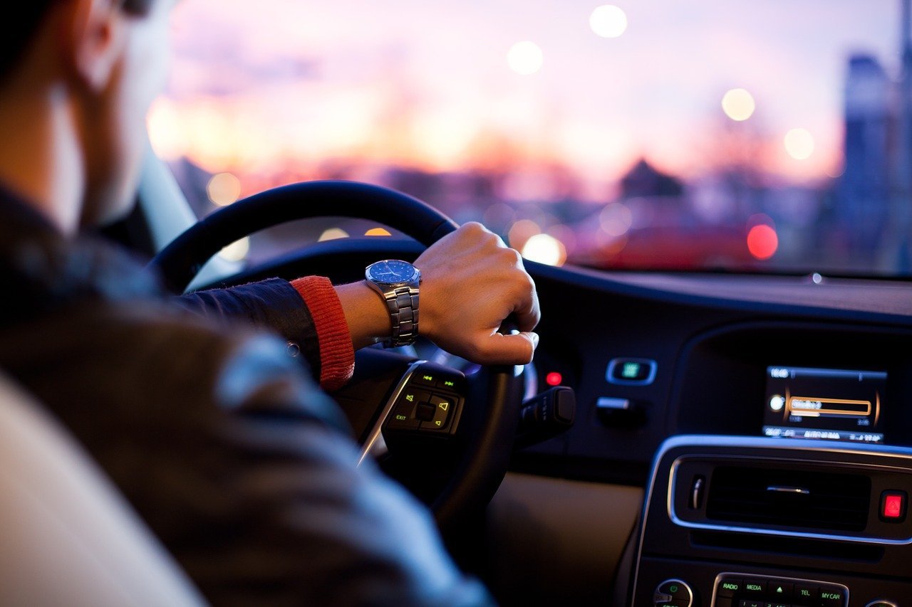 Homme vu de derrière qui conduit une voiture