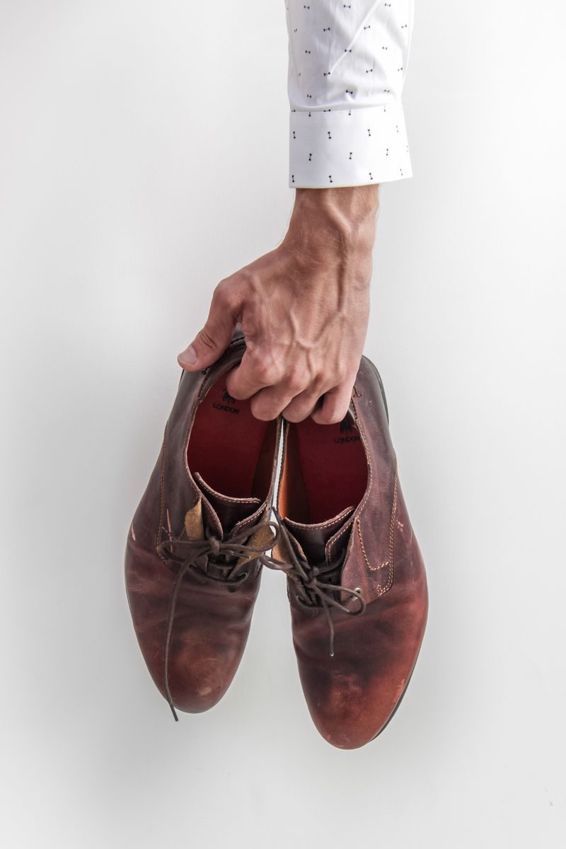 Homme tient paire de chaussures marron