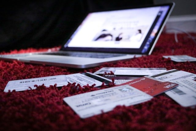 Ordinateur portable posé sur un tapis rouge avec différentes cartes de crédit