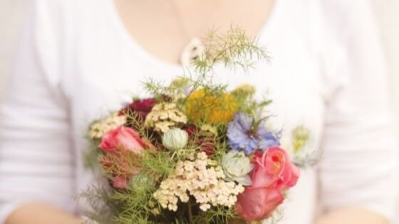 Frau hält bunten Blumenstrauß in den Händen