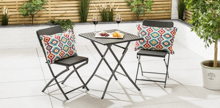 Christow Home savings banner showing a bistro set with vibrant cushions on a garden patio
