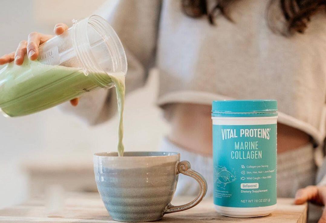Une femme versant une boisson au collagene marin Vital Proteins dans une tasse