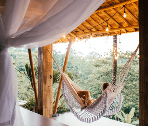 Person on holiday in a hammock overlooking some trees