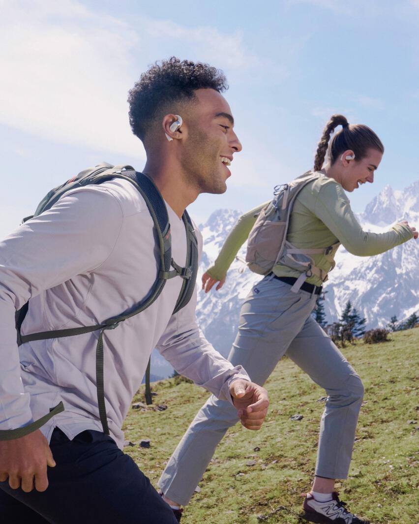 Couple hiking while wearing Shokz headphones
