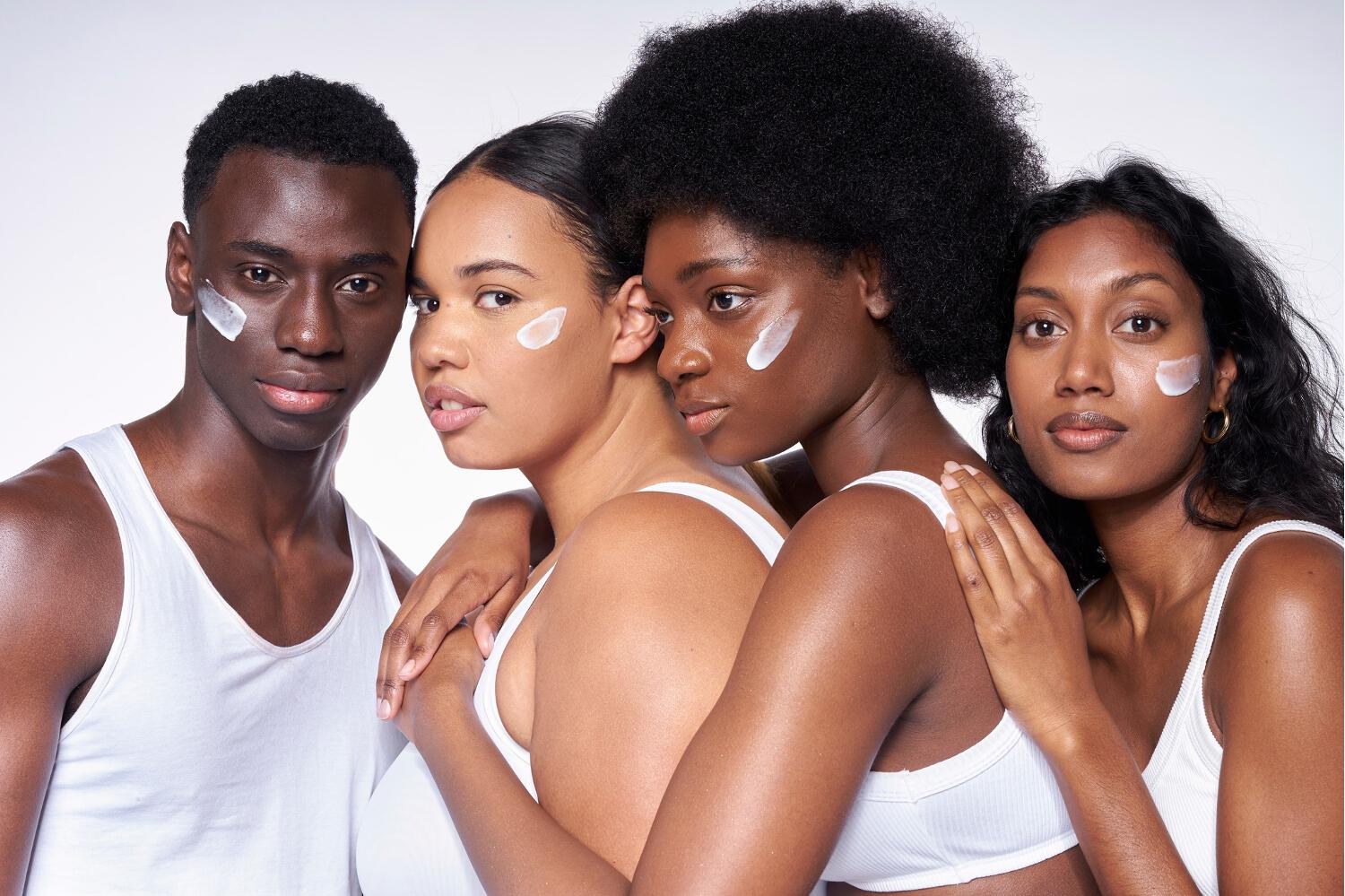 Quatre mannequins à peaux noires et métisses avec un trait de crème Nubiance