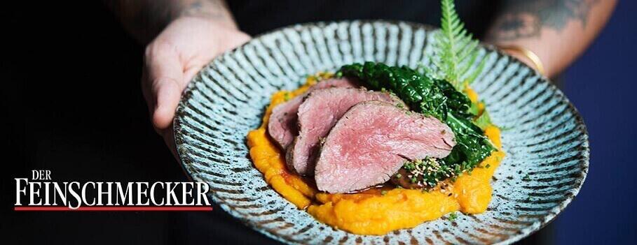 Präsentierter Teller mit Kalbsbraten auf Püree mit Shop-Logo als Banner für die FeinschmeckerShop Gutscheinseite