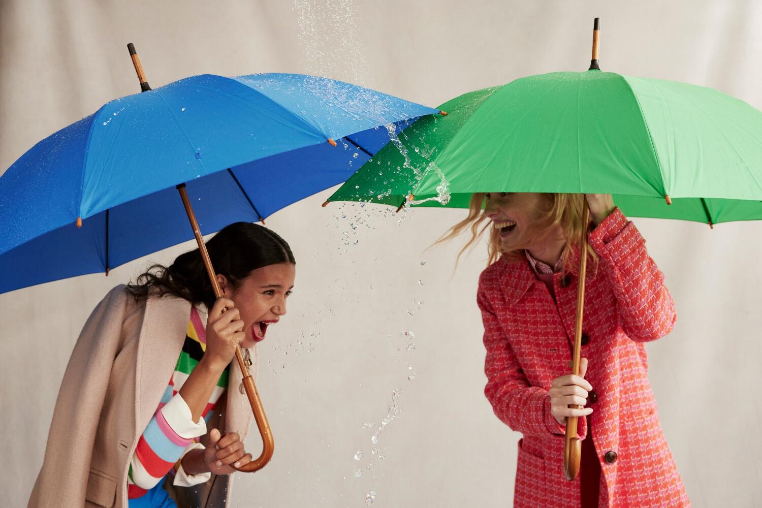 deux mannequins enfants portant tenues Boden et un parapluie coloré