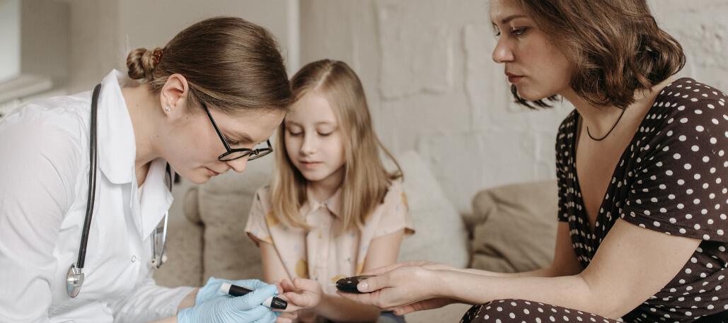 female nurse checking the bloods of child in view of mother