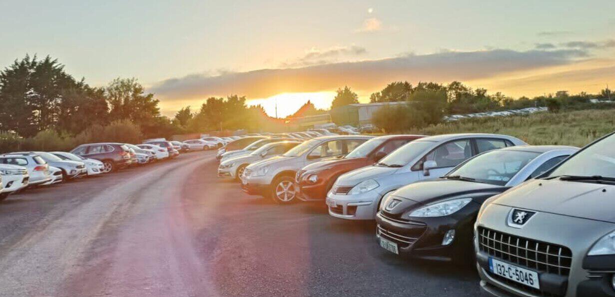 Dublin Airport Parking banner showing a row of parked cars in the sunshine