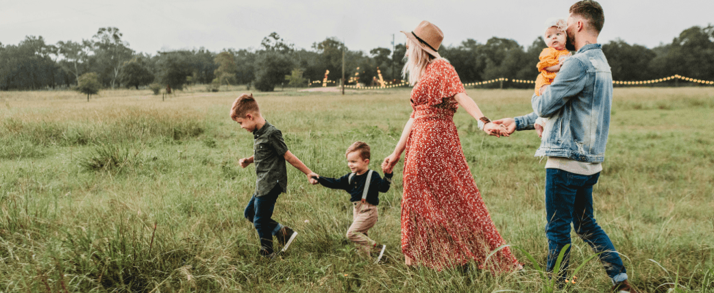Easter resort family holiday image showing a mum and dad with two children waking across a field