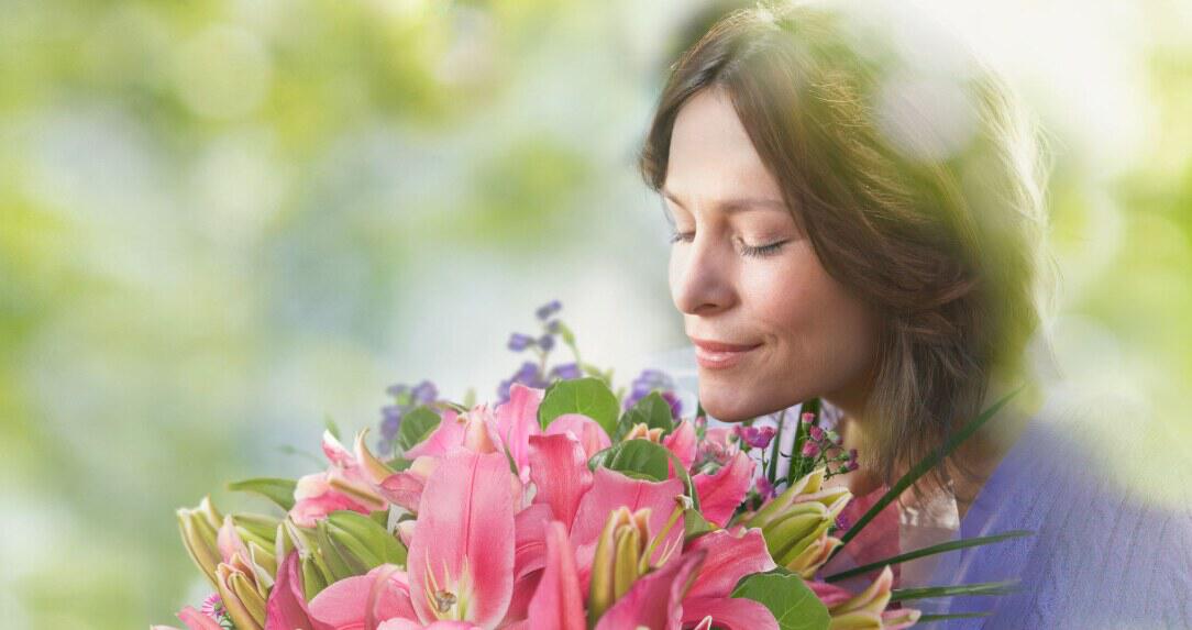 easyflowers deals page banner showing a woman holding a bouquet of flowers to her nose outdoors