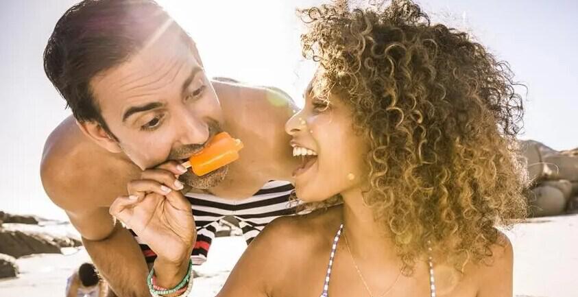 easyJet clever ways to save image featuring a couple on a beach messing around with an ice lolly