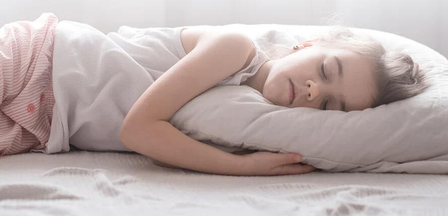Eco Kids deals page image - A young girl sleeping on a bed