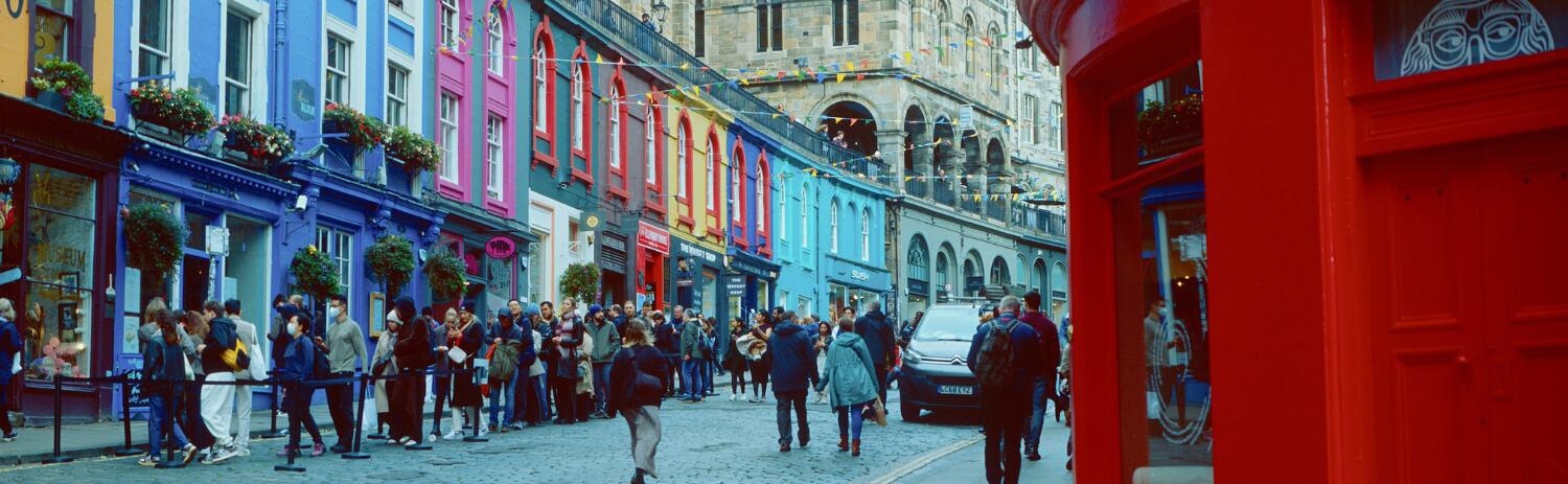 Edinburgh fringe street scene showing a queue of people waiting to see a show