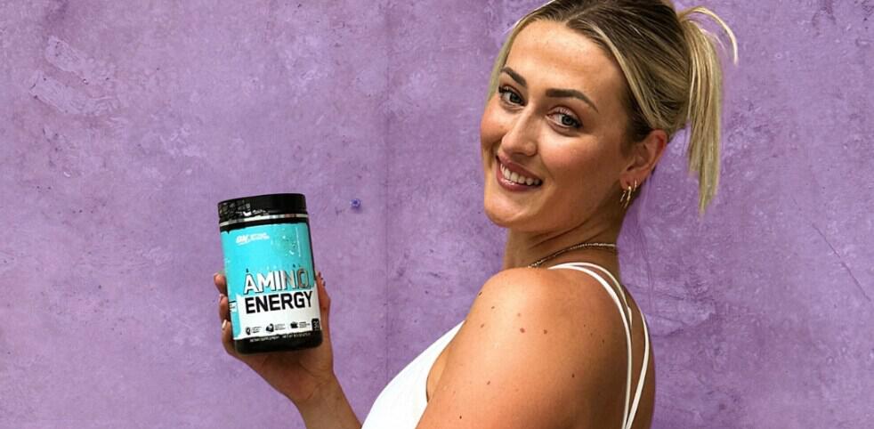 Elite Supplements ways to save image - Woman holiding an Amino Energy bottle in front of a purple background