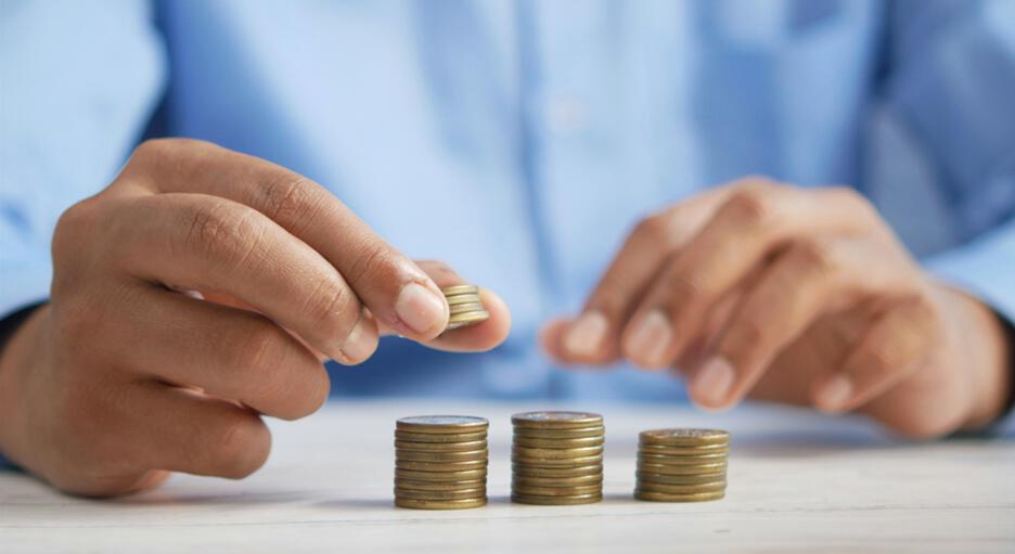 Close up of a man stacking a pile of coins