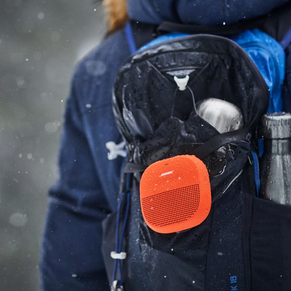 enceinte bluetooth portable accrochée à un sac à dos en montagne