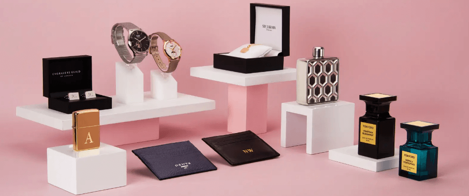 image of a display of various watches,gifts and perfume on a pink background
