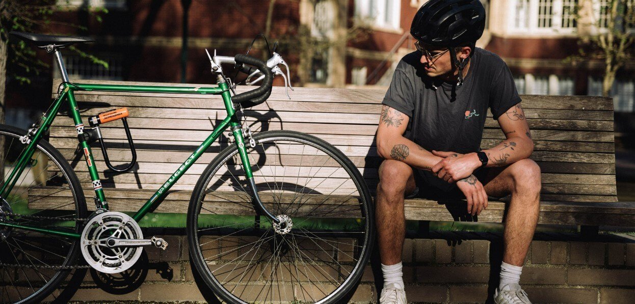 Evans Cycles –Man sitting on bench beside a bike