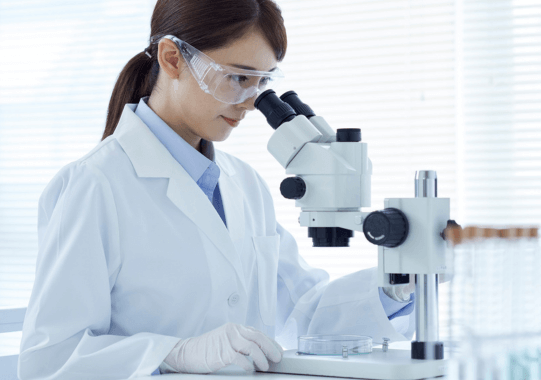 Female scientist looking through microscope