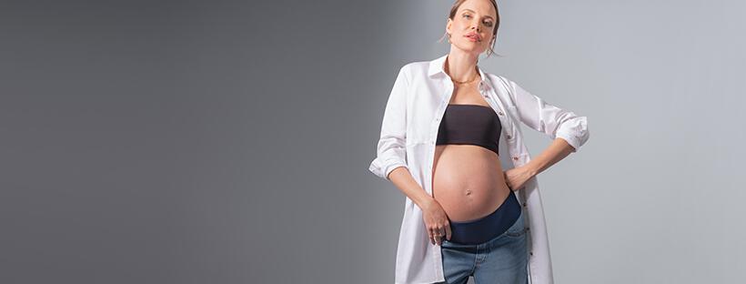 Femme enceinte portant des sous-vêtements de maternité Seraphine sous une chemise ouverte
